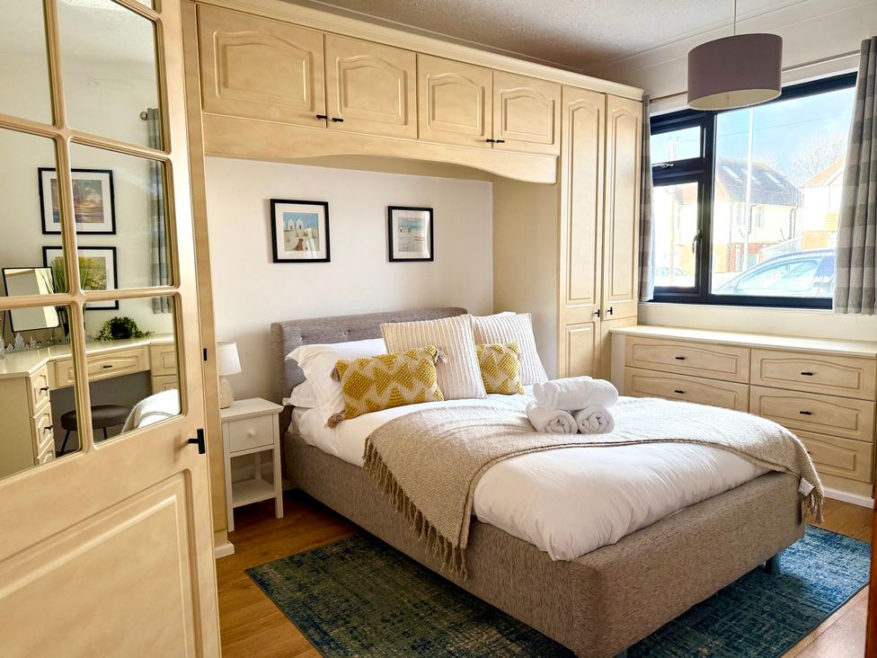 A bedroom with a bed and wardrobe at Crows Nest Dawlish