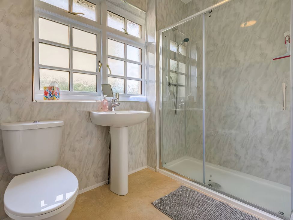 A bathroom with a sink, toilet, and shower at Crows Nest Dawlish