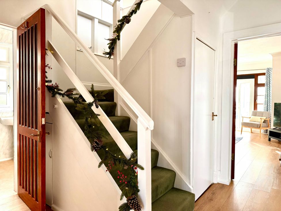 A staircase with a decorative garland in a hallway at Crows Nest Dawlish