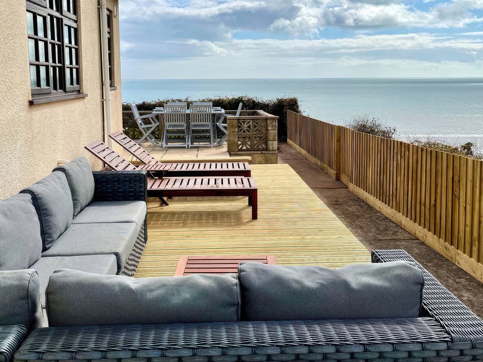 An outdoor area with seating and a table at Crows Nest Dawlish