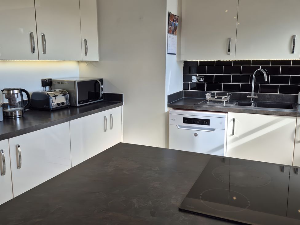 A kitchen with appliances including kettle, toaster, and microwave at 54 swallow road
