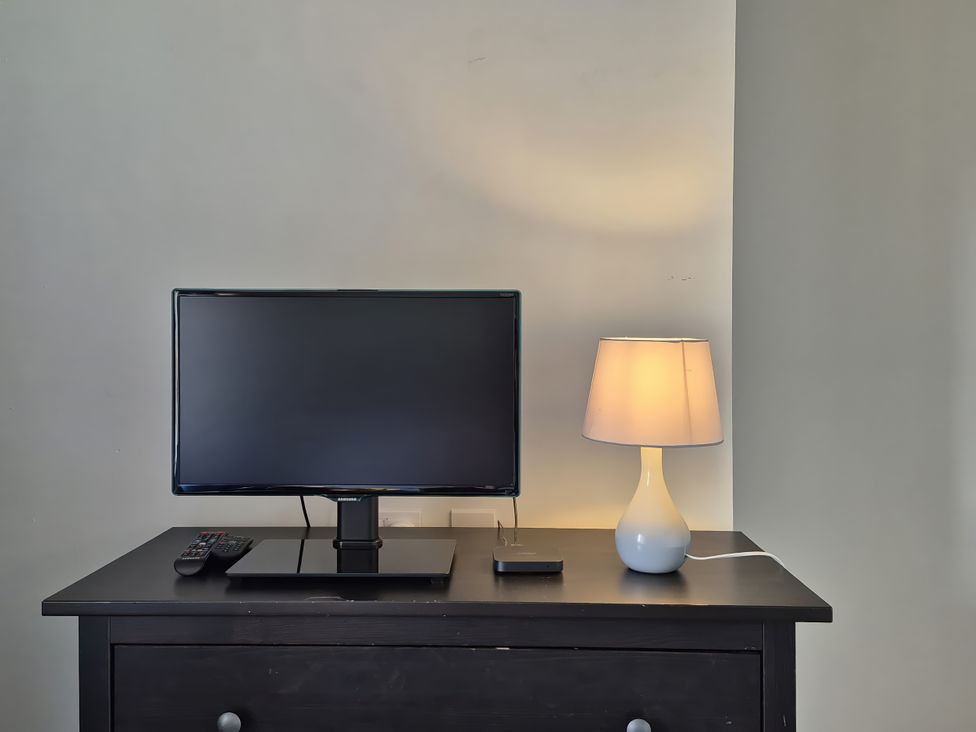 A television and lamp on a table at 54 swallow road