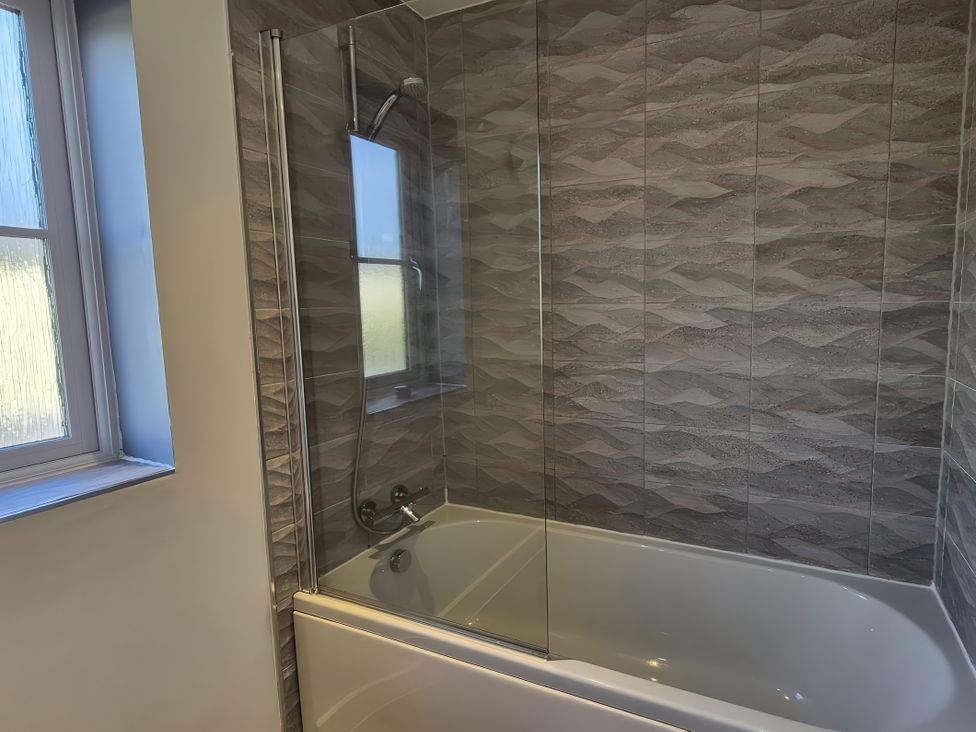 A bathroom with a bathtub and shower at 54 swallow road