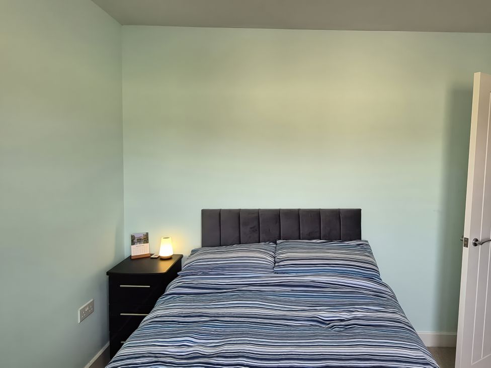A bedroom with a bed and nightstand at 54 swallow road