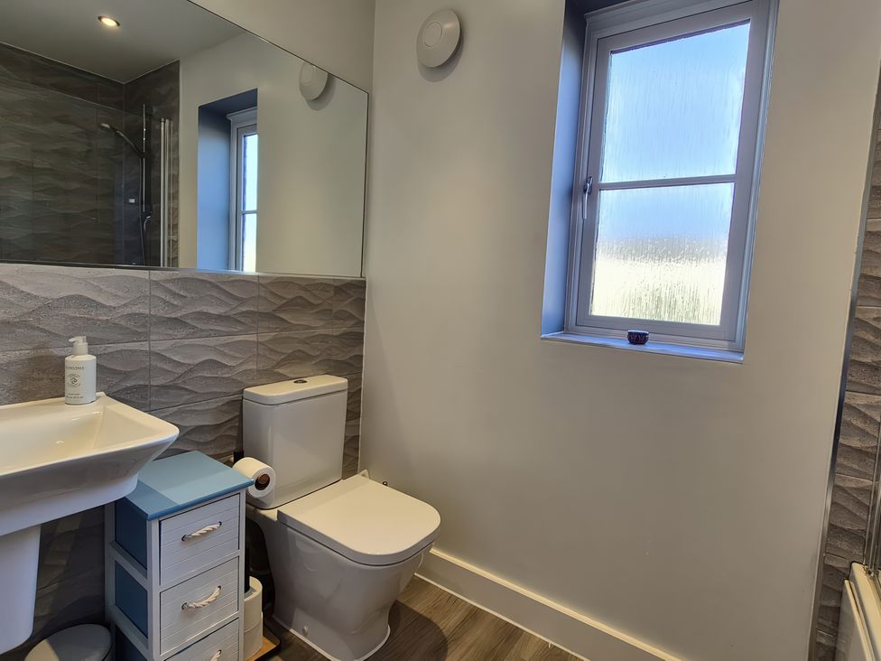 A bathroom with a toilet, sink, and window at 54 swallow road
