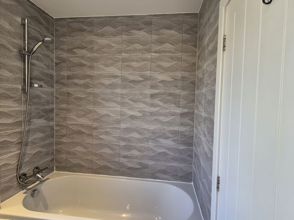 A bathroom with a shower over a bathtub at 54 swallow road