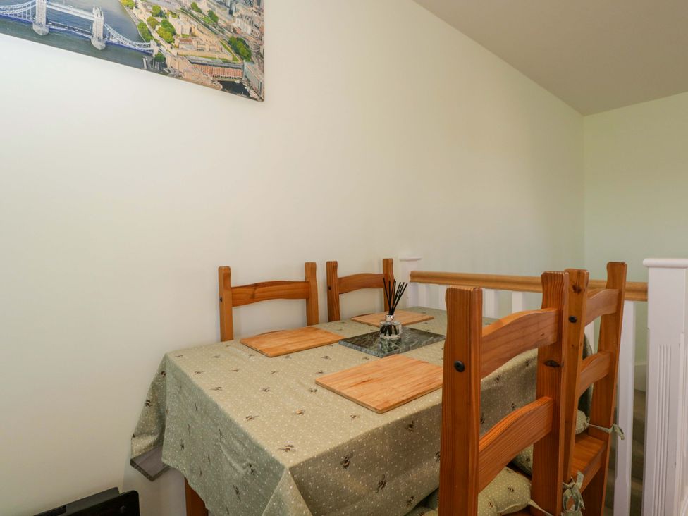 A dining room with a wooden table and chairs at Swallows Nest in Bourton-On-The-Water