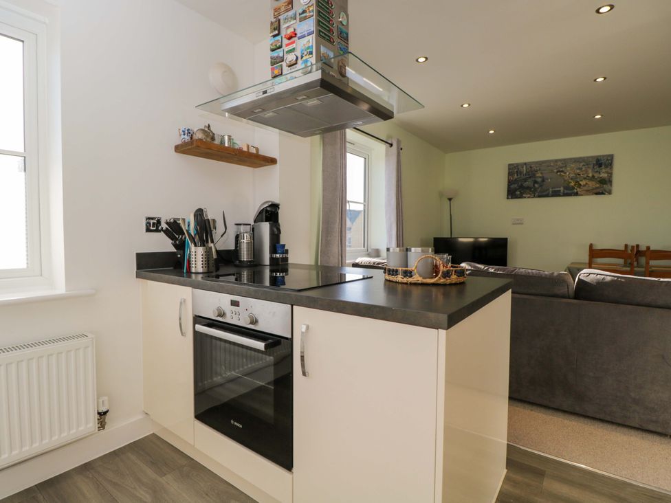 A kitchen area with appliances and seating at Swallows Nest in Bourton-On-The-Water