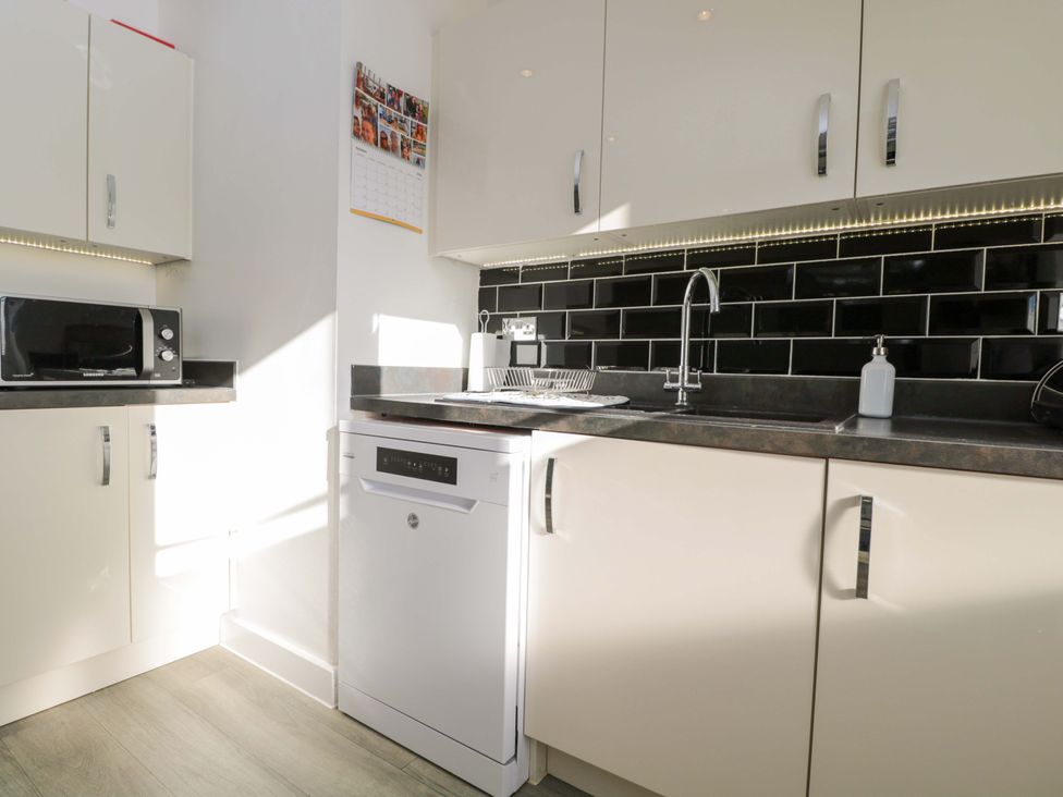 A kitchen with a sink and dishwasher at Swallows Nest in Bourton-On-The-Water