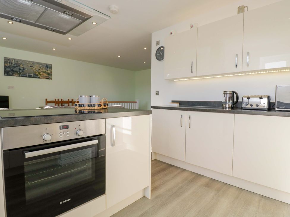 A kitchen with oven, kettle, toaster, and kitchen cabinets at Swallows Nest Bourton-On-The-Water
