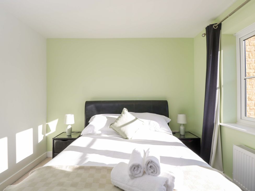 A bedroom with a bed and nightstand at Swallows Nest Bourton-On-The-Water