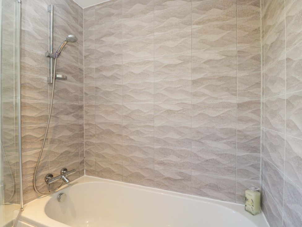 A bathroom with a bath tub and shower at Swallows Nest in Bourton-On-The-Water