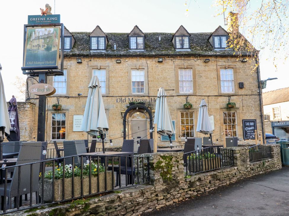 An outdoor seating area with tables and umbrellas at Old Manse Hotel in Bourton-On-The-Water