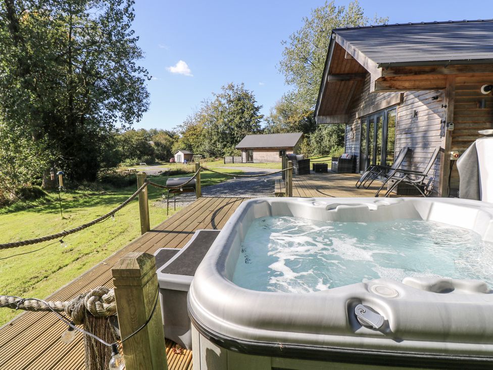 A hot tub on decking in an outdoor area at Cadno in Llanybydder