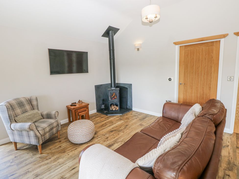 A living room with a stove and furniture at Cadno in Llanybydder