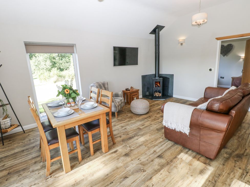 A living room with a sofa and dining table at Cadno in Llanybydder