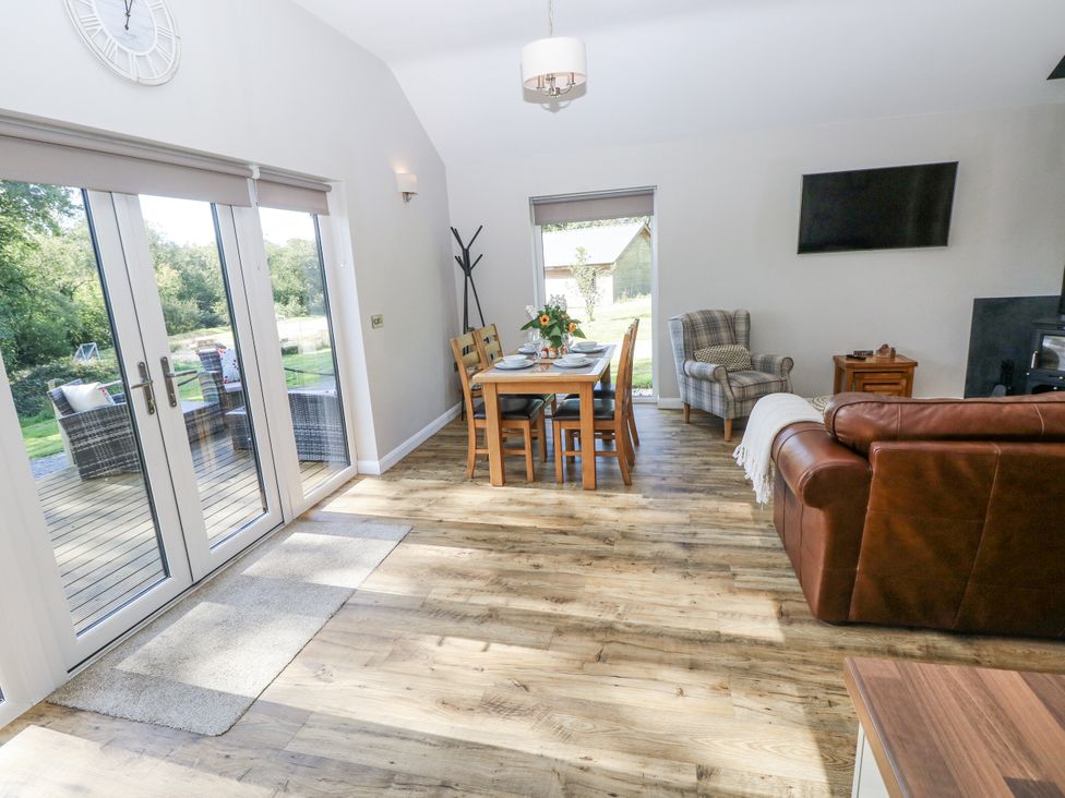 A living room with a sofa and dining table at Cadno Llanybydder