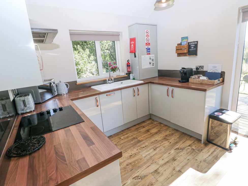 A kitchen with a sink and appliances at Cadno in Llanybydder