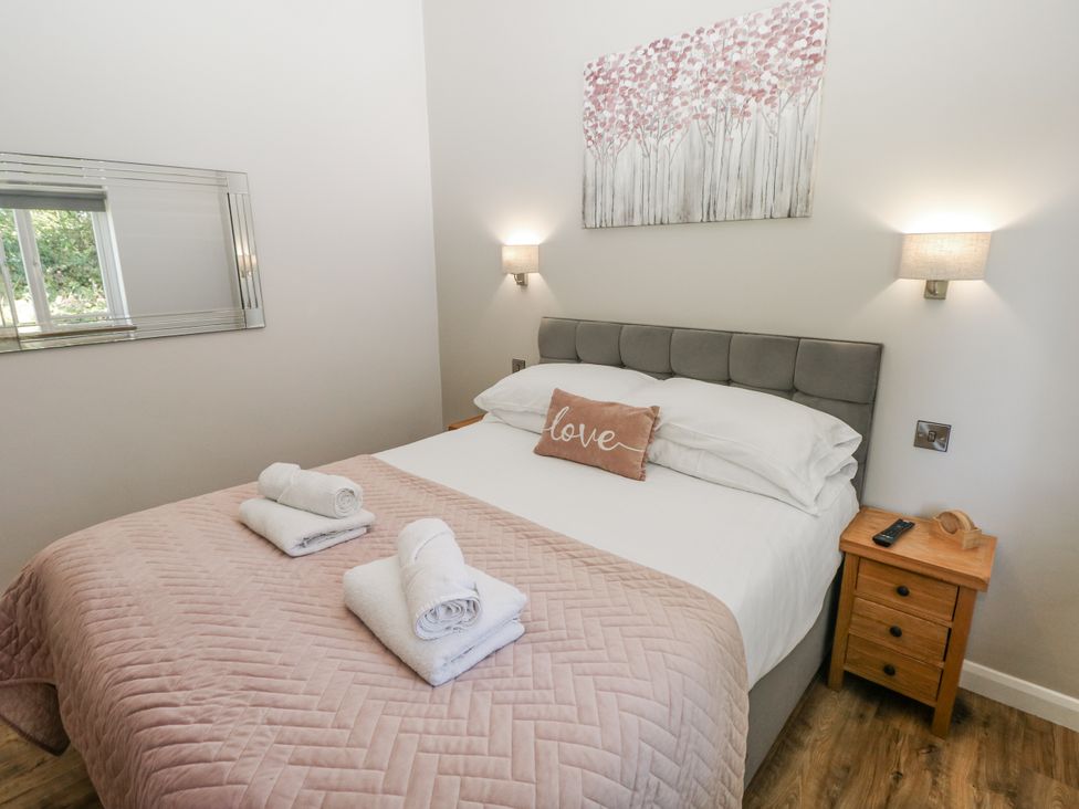 A bedroom with a bed and bedside table at Cadno in Llanybydder