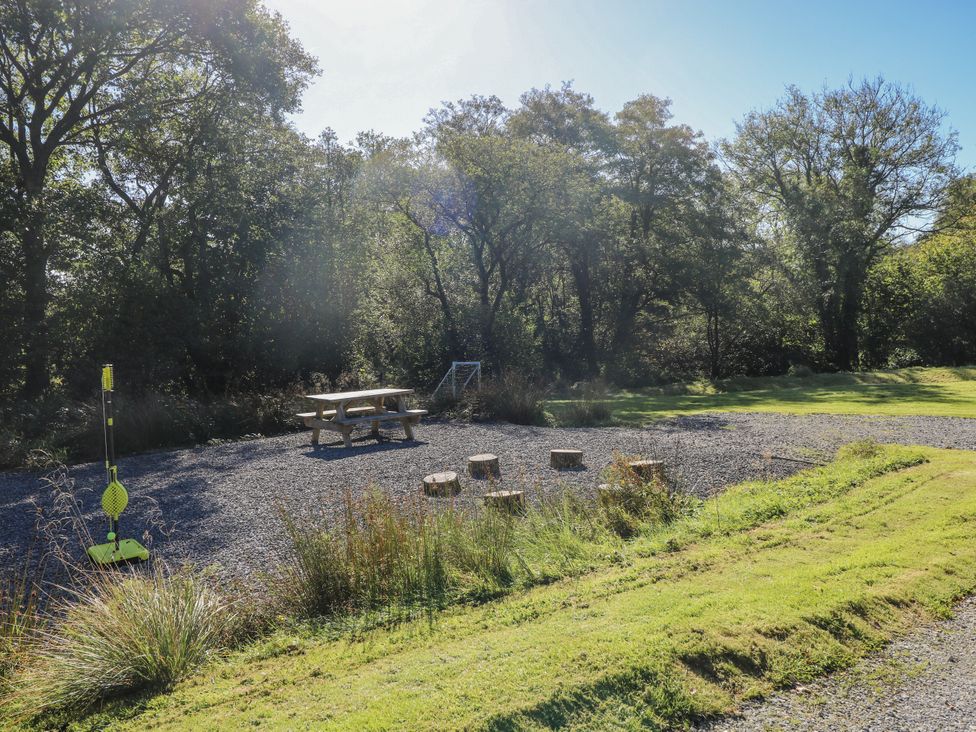An outdoor seating area with a table and logs at Cadno Llanybydder