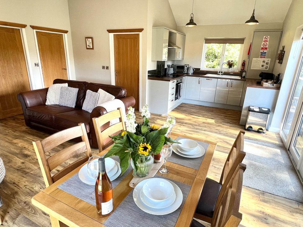An open plan living space with a dining table and kitchen area at Cadno Aber near Llanybydder