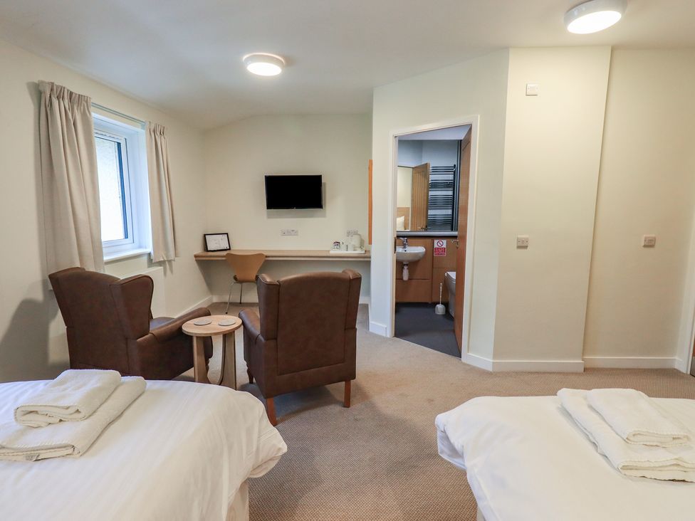 A bedroom with two beds and seating area at Railway Retreat at Eamont Park in Penrith
