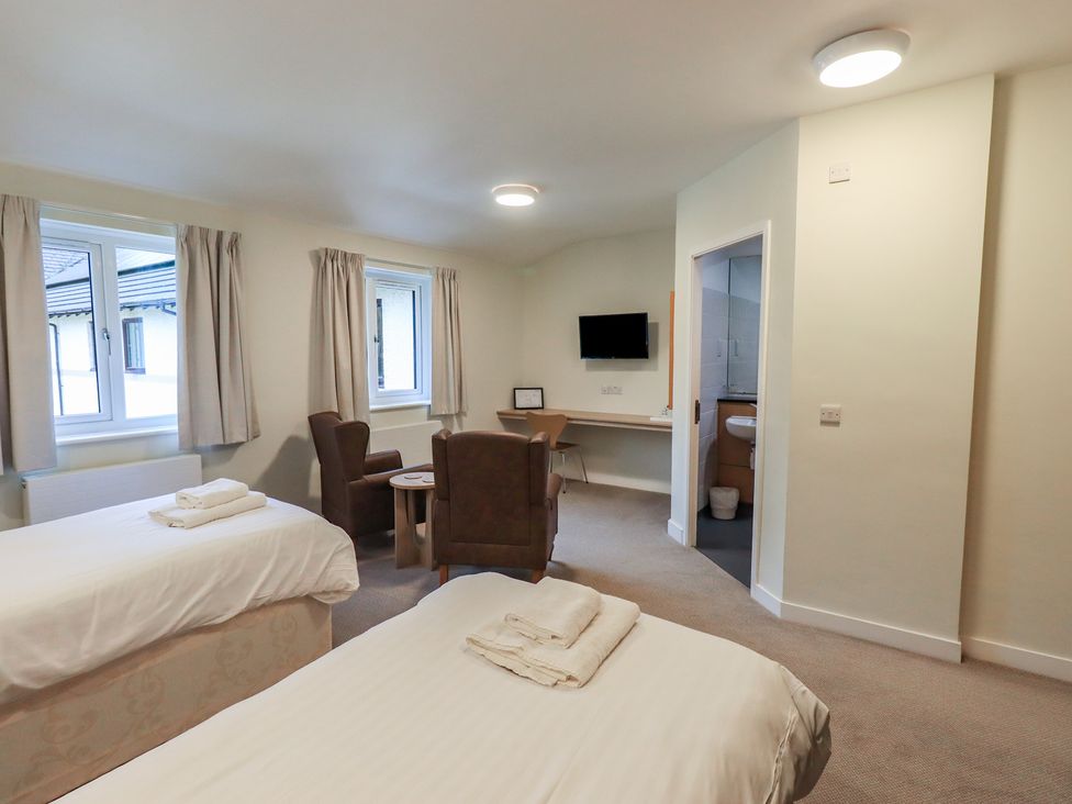 A bedroom with two beds and a table at Railway Retreat at Eamont Park Penrith