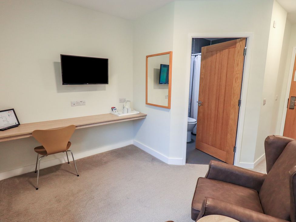 A guest room with a TV and a desk at Railway Retreat at Eamont Park Penrith