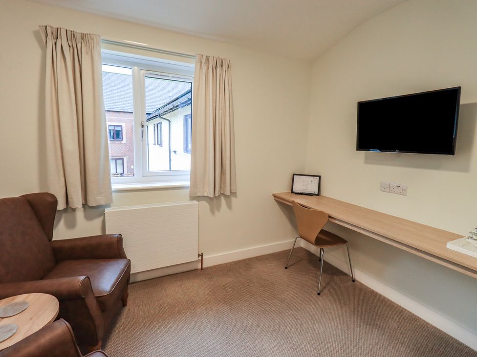 A bedroom with a chair and desk at Railway Retreat at Eamont Park, Penrith