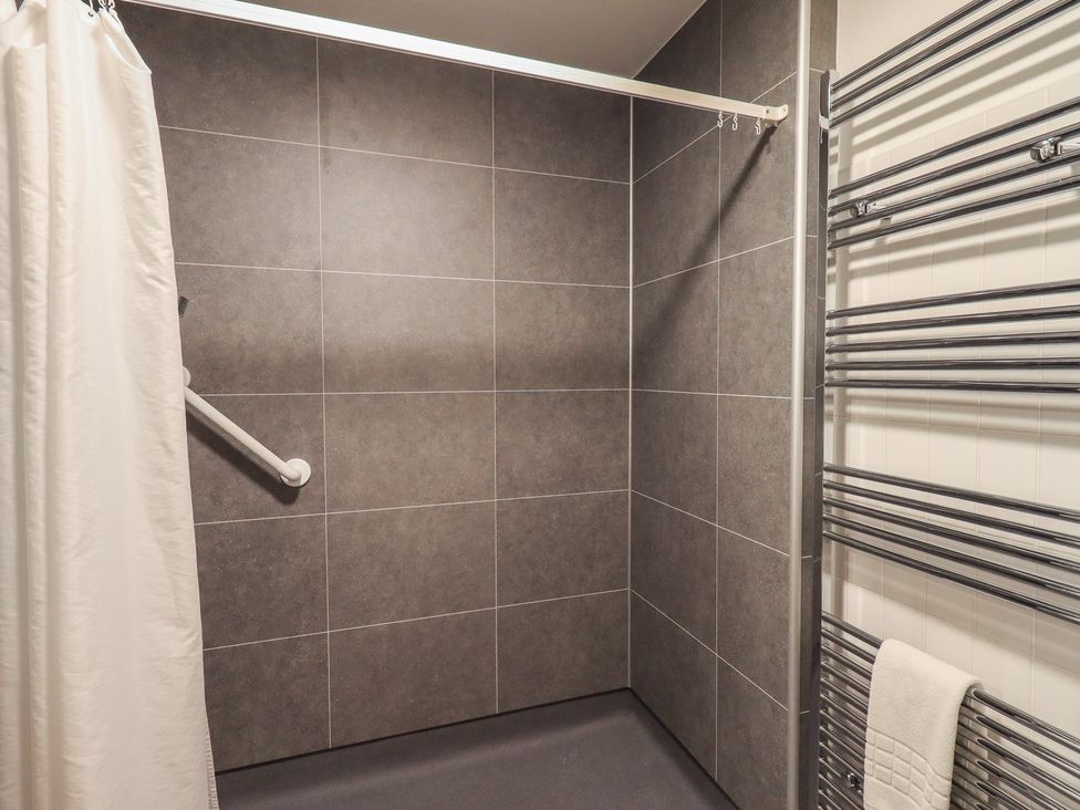 A shower area with grey tiles and a towel rail at Railway Retreat at Eamont Park Penrith