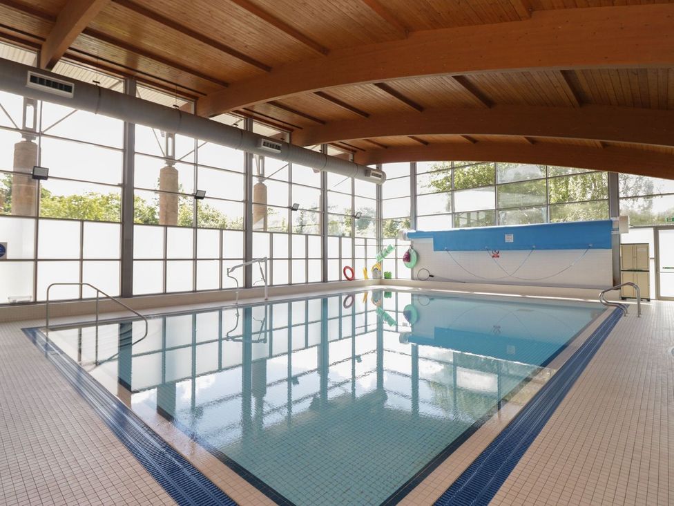 An indoor swimming pool with large windows at Railway Retreat at Eamont Park Penrith