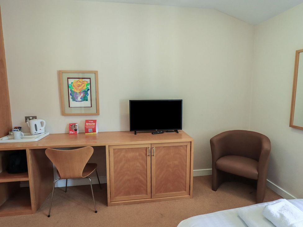 A bedroom with a television and desk at Thacka Beck Retreat at Eamont Park Penrith