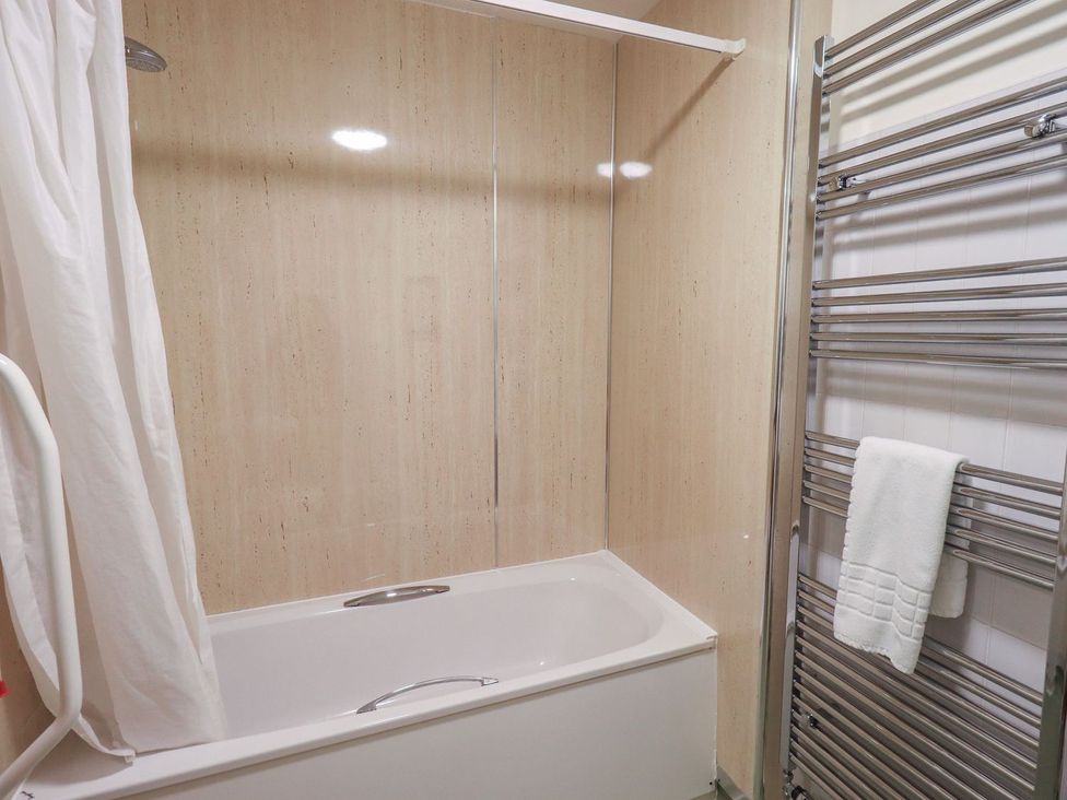 A bathroom with a bathtub and towel rail at Thacka Beck Retreat at Eamont Park Penrith