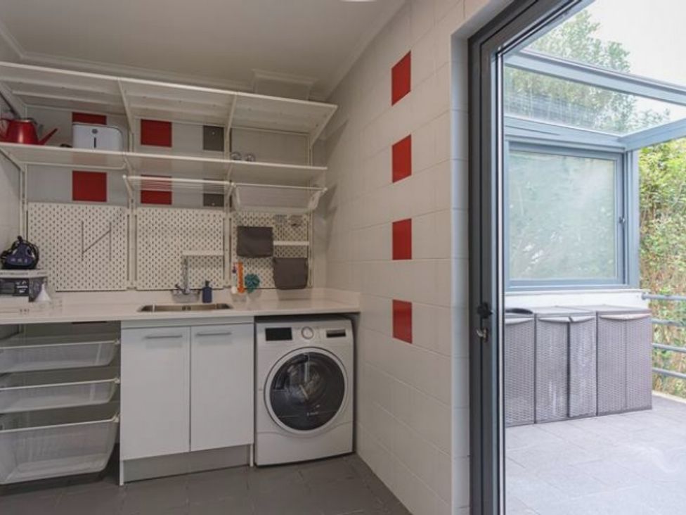 A laundry room with a washing machine and shelves at the property in 