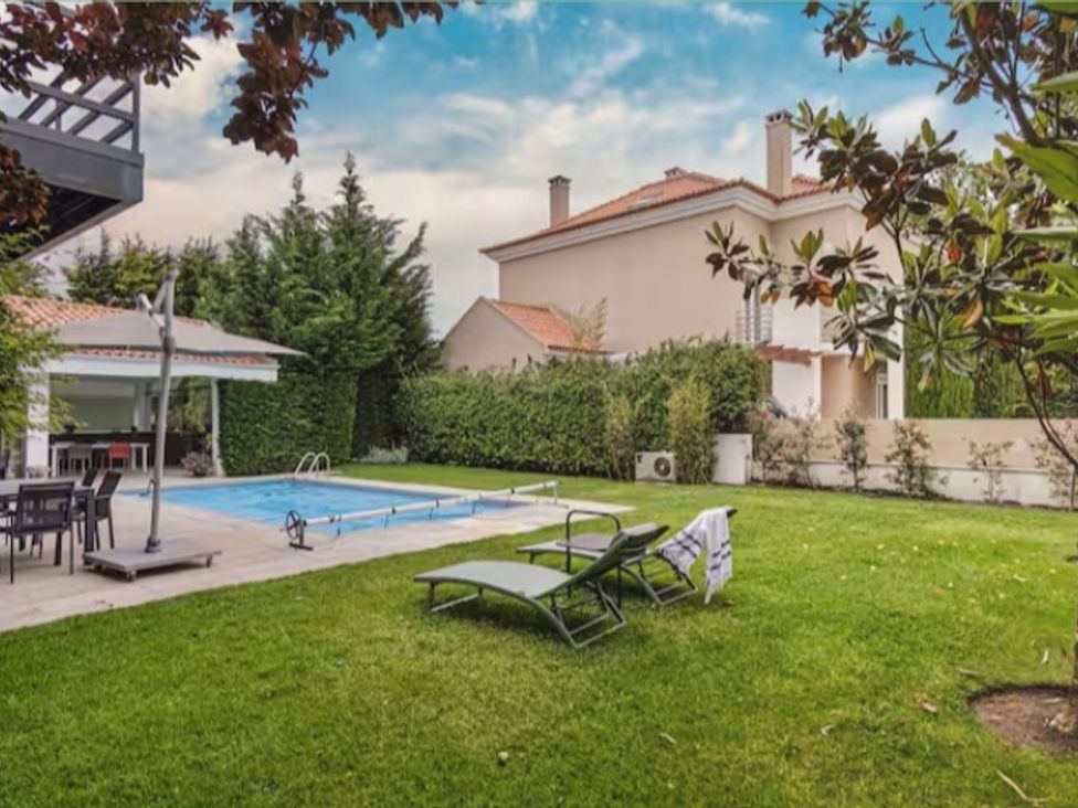 A garden with a swimming pool and deck chairs at a property