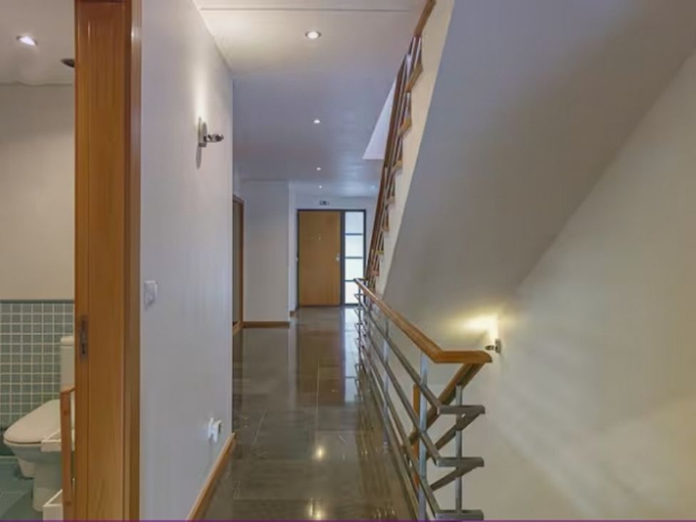 A hallway with a toilet and door at the property in 