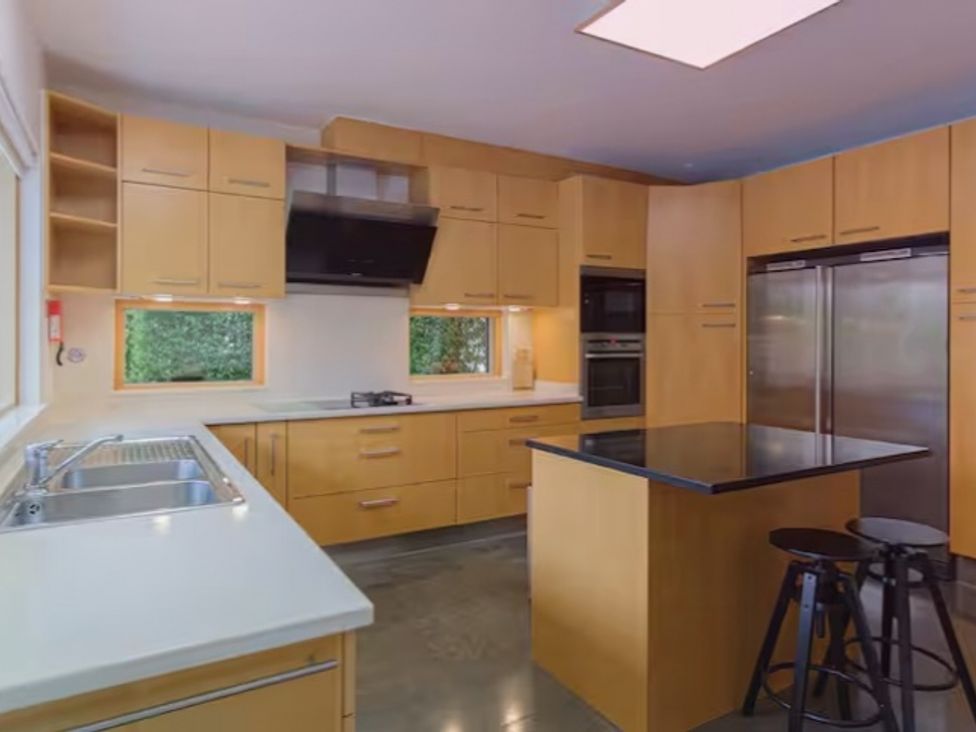 A kitchen with cabinets, sink, stove, and refrigerator at 