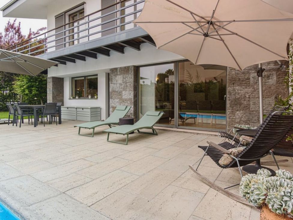 A patio area with sunbeds and a table at a residential property