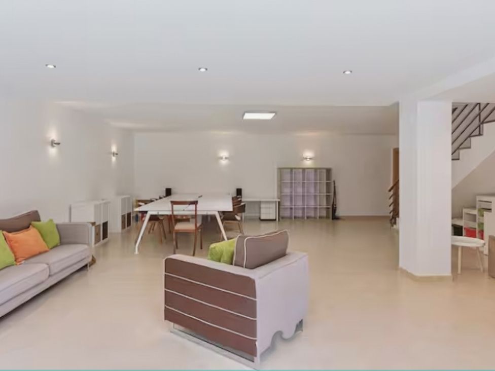 A living room with a sofa, table, and shelves at the property in 