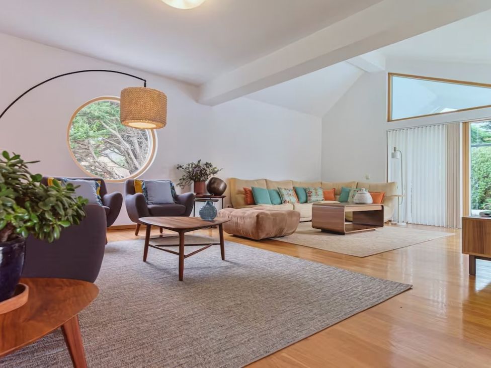 A living room with a sofa, chairs, a table, and a window at the property