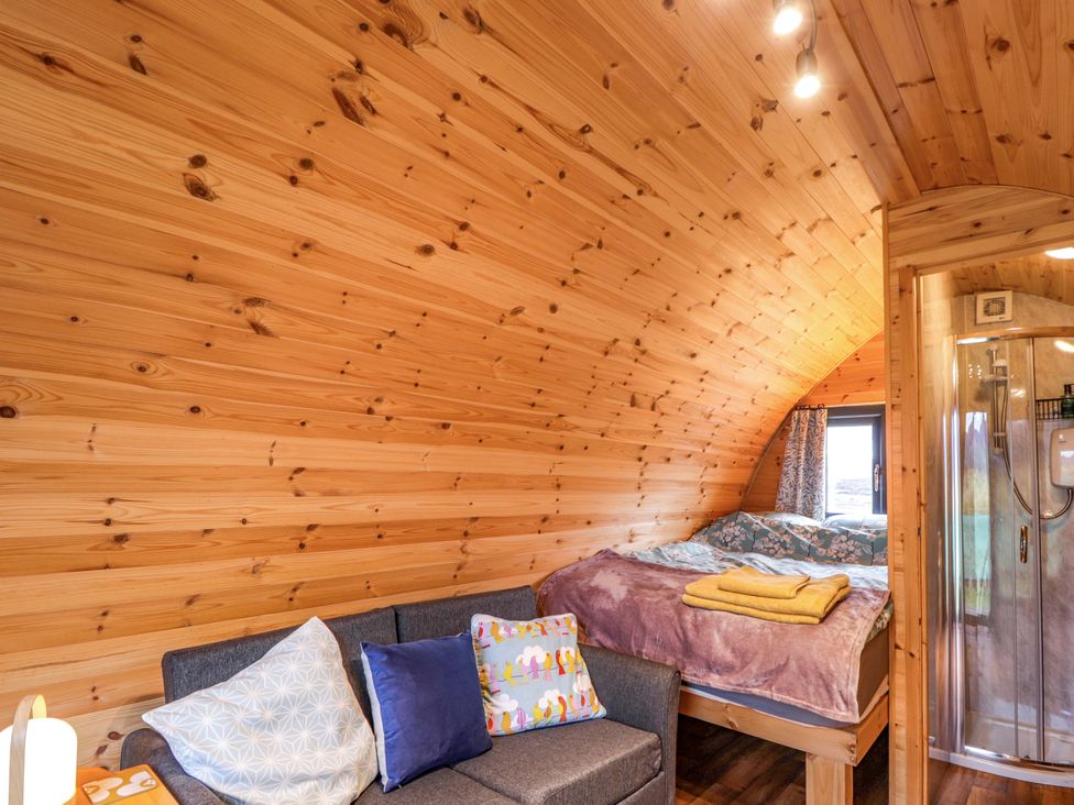 A bedroom with a bed and couch at The Pod at Greenbank Isle of Skye