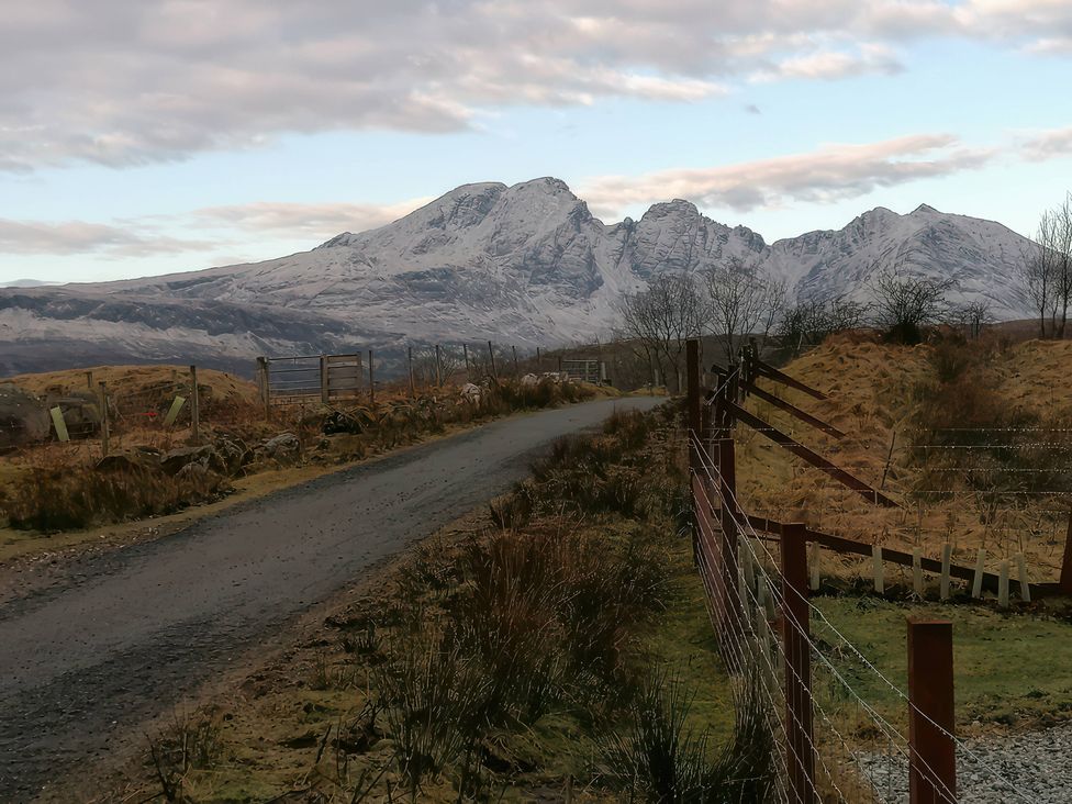 A mountain view with a road and fence at The Pod at Greenbank Kilbride near Broadford