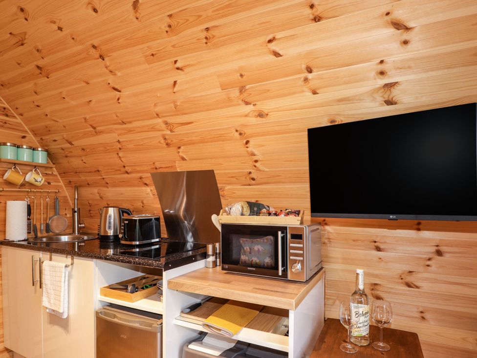 A kitchen with appliances and a TV at The Pod at Greenbank Kilbride near Broadford