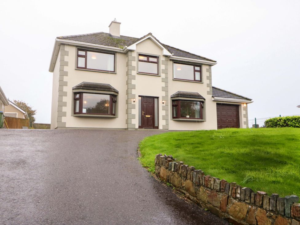 A house with a driveway and garage at Shamrock House 