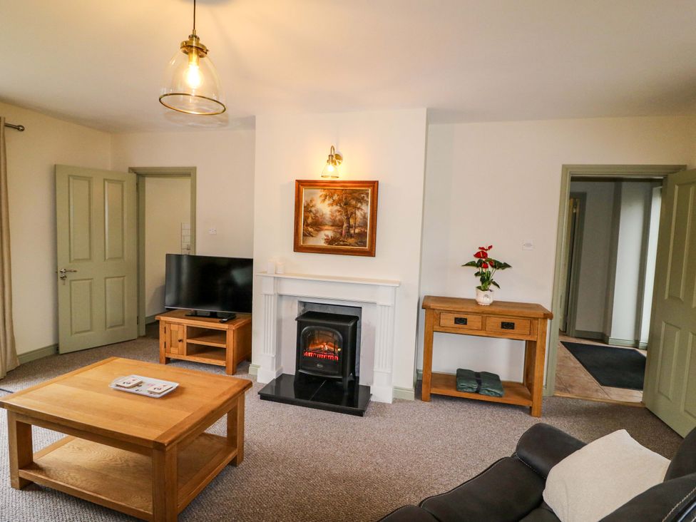 A living room with a fireplace and television at Shamrock House