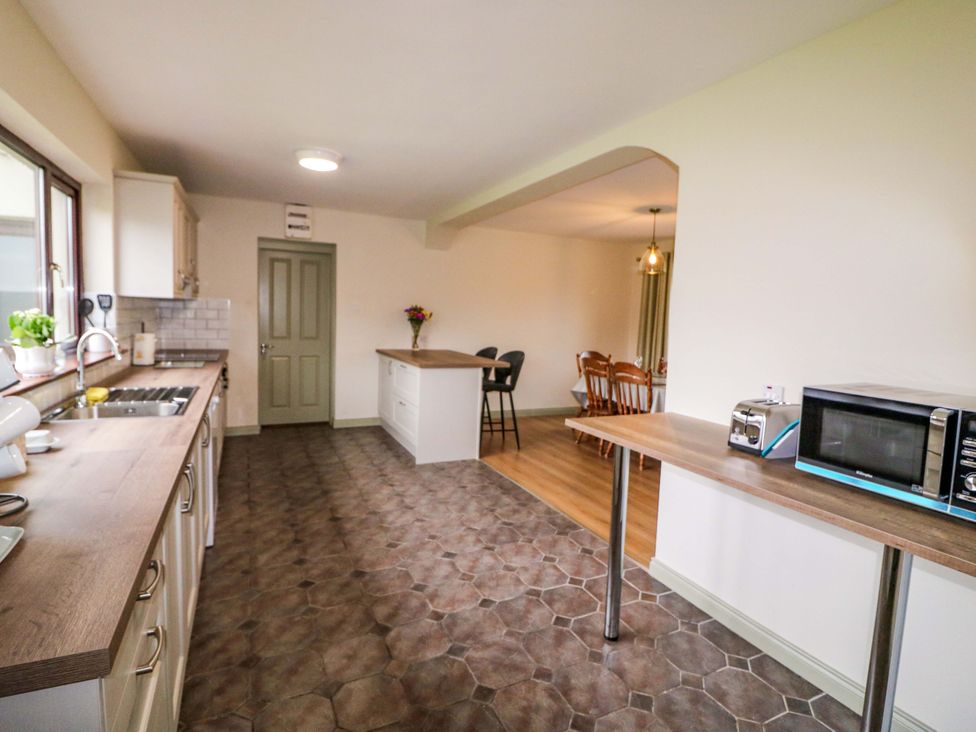A kitchen with counter, stove and sink at Shamrock House