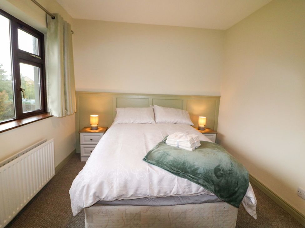 A bedroom with a bed and nightstands at Shamrock House