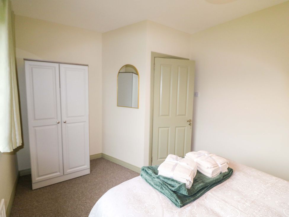 A bedroom with a wardrobe and towels at Shamrock House