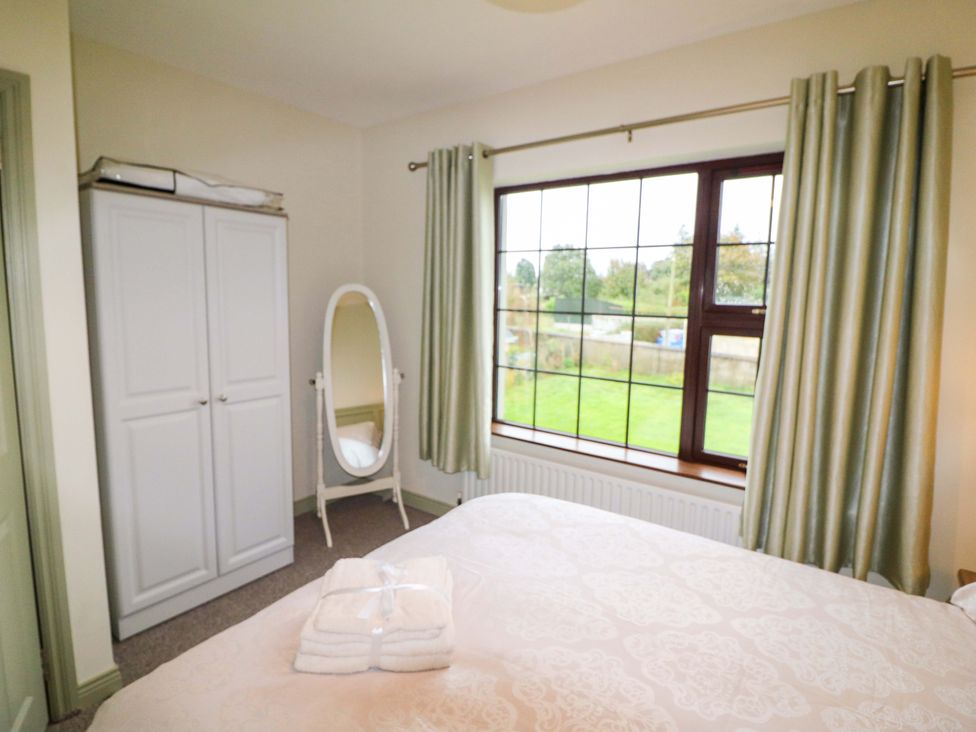 A bedroom with a bed and wardrobe at Shamrock House