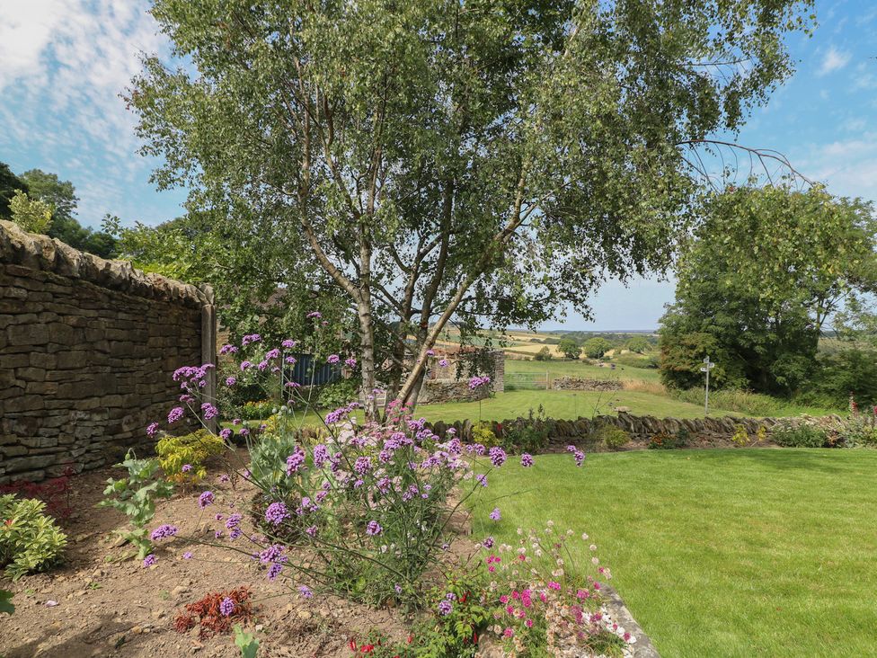 A garden with flowers and trees at Wigley House Farm Bungalow in Chesterfield